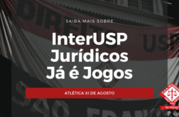 #PraCegoVer: O fundo da foto mostra estendida uma bandeira, vermelha, branca e preta, com a identificação da Faculdade de Direito do Largo São Francisco e, ao centro, o emblema da A.A.A. XI de Agosto. No centro, encontra-se escrito "Saiba mais sobre - InterUSP, Jogos Jurídicos e Já é jogos - Atlética XI de Agosto" nas cores vermelho, branco e preto. 